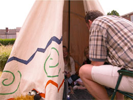 Martin telling stories to children in a teepee in the house's garden